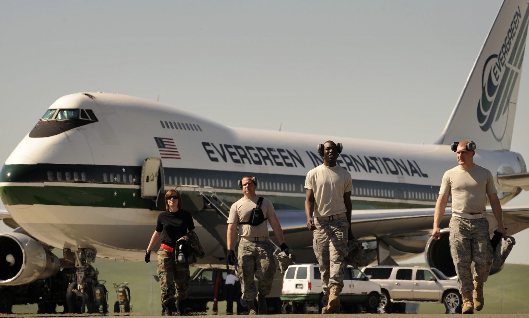 Boeing 747 freighter with nose cargo door open during loading operations.