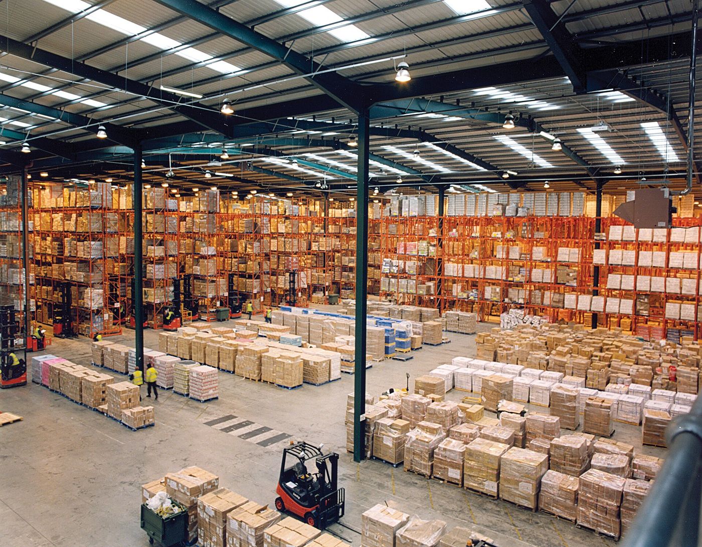 Modern warehouse interior with high pallet racking and orderly aisles.